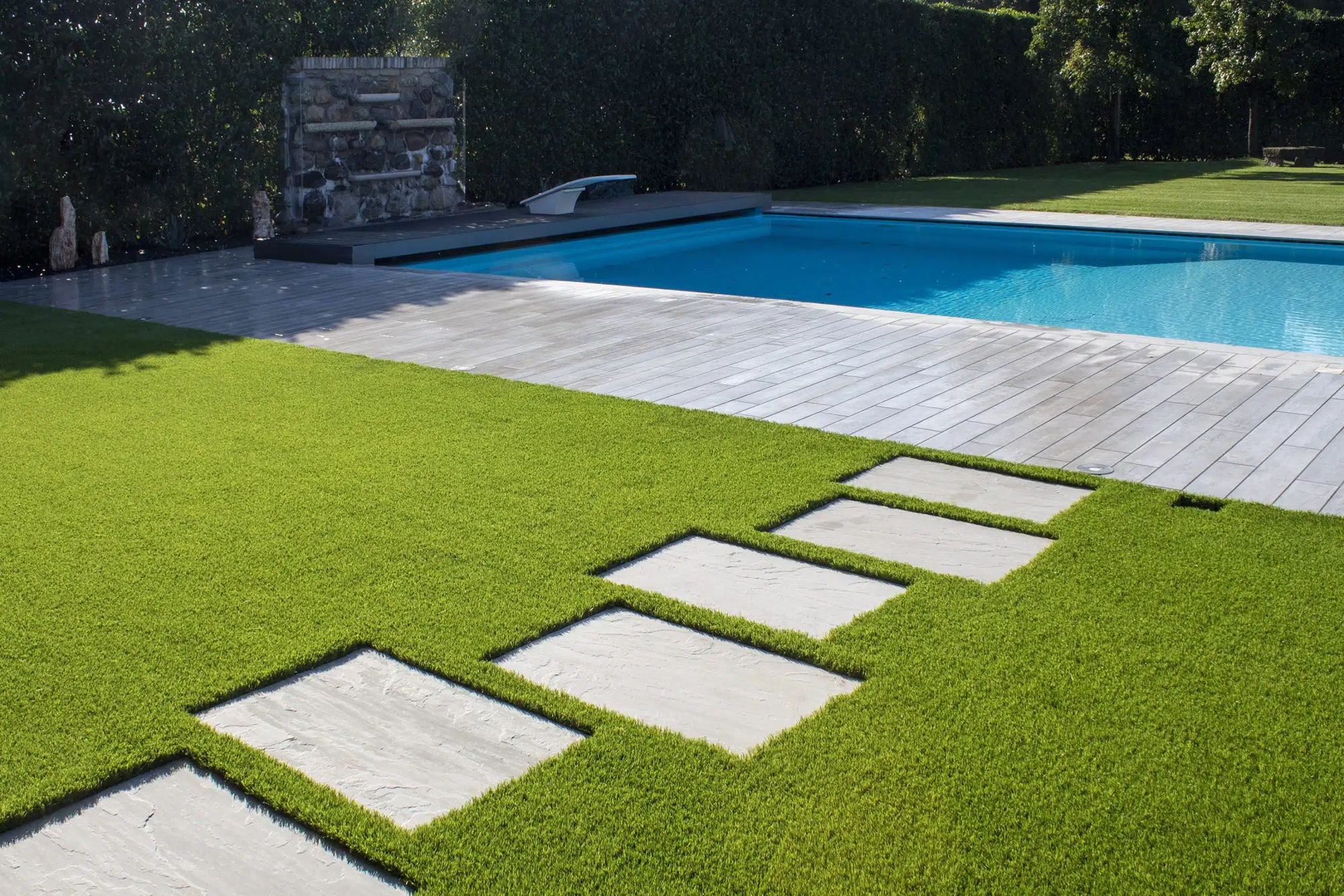 Piscina con lastre e prato sintetico